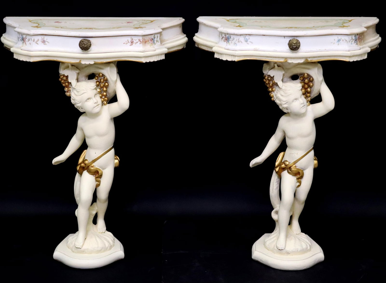 (2) VENETIAN PAINT-DECORATED CHERUB CONSOLES: (pair) Italian Venetian paint-decorated wall brackets/ console tables, 20th c., each having shaped top, over single drawer, rising on figural putti standard, with gilt painted accents, ending on shell