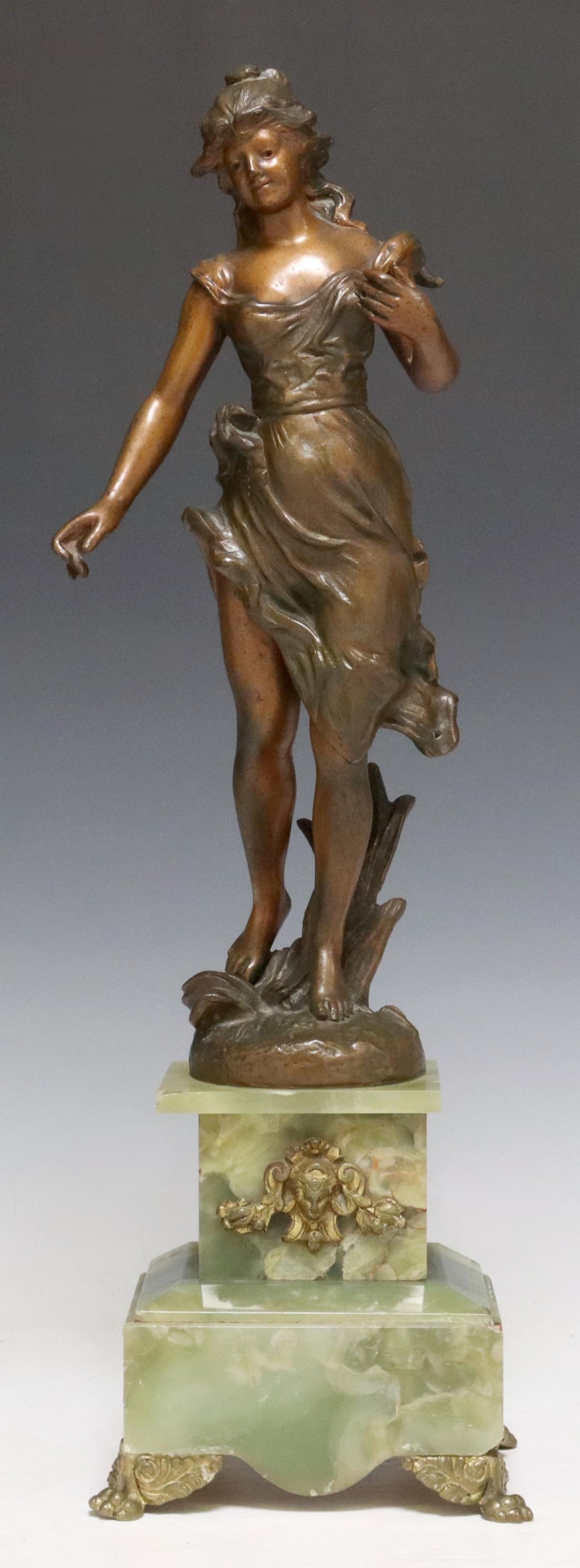 AFTER AUGUSTE MOREAU (D.1917) FIGURAL SCULPTURE: Patinated metal sculpture, Standing Woman, after the original by Auguste Moreau (French, 1834-1917), rising on green onyx plinth base with metal mount and foliated paw feet, some chipping to base edge