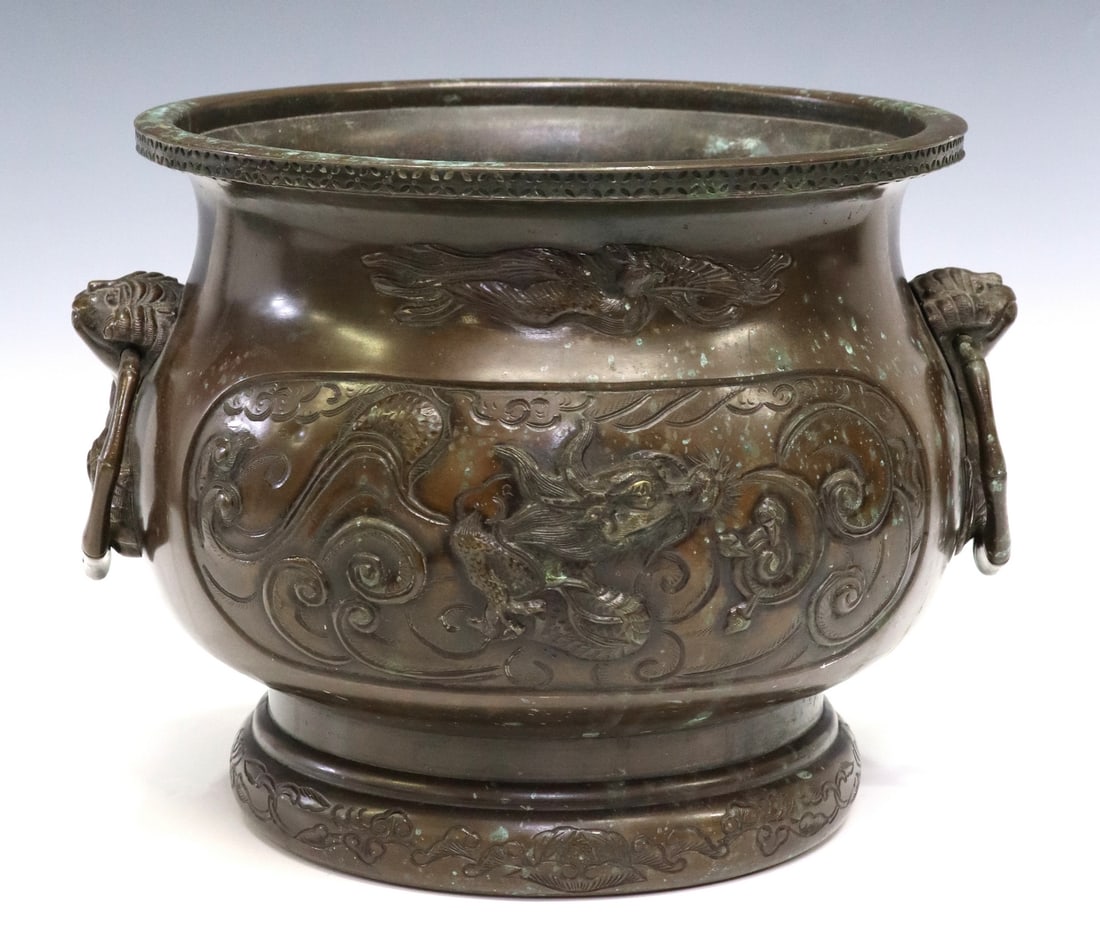 JAPANESE MEIJI PERIOD BRONZE JARDINIERE PLANTER: Japanese bronze jardiniere/ planter, Meiji period (1868-1912), having pierced trim, mythical motifs depicting dragons, birds, and grotesque masks, side handles, ending on circular base, approx 9.25"h,
