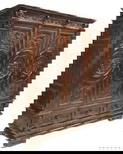 ITALIAN RENAISSANCE REVIVAL CARVED WALNUT ARMOIRE: Italian Renaissance Revival carved walnut armoire, early 20th c., molded cornice, three doors with coats of arms centering a female mask, interior hanging rod and shelves, three exterior drawers below