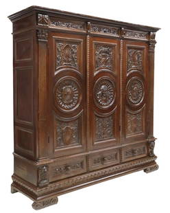 ITALIAN RENAISSANCE REVIVAL CARVED WALNUT ARMOIRE: Italian Renaissance Revival carved walnut armoire, early 20th c., molded cornice, three doors with coats of arms centering a female mask, interior hanging rod and shelves, three exterior drawers below