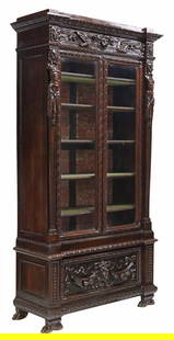 ITALIAN RENAISSANCE REVIVAL CARVED WALNUT BOOKCASE: Italian Renaissance Revival walnut bookcase/ display cabinet, late 19th c., two glazed doors with beveled glass insets, interior lined in marbleized paper, velvet-lined shelves, lower section with a d