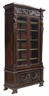 ITALIAN RENAISSANCE REVIVAL CARVED WALNUT BOOKCASE: Italian Renaissance Revival walnut bookcase/ display cabinet, late 19th c., two glazed doors with beveled glass insets, interior lined in marbleized paper, velvet-lined shelves, lower section with a d