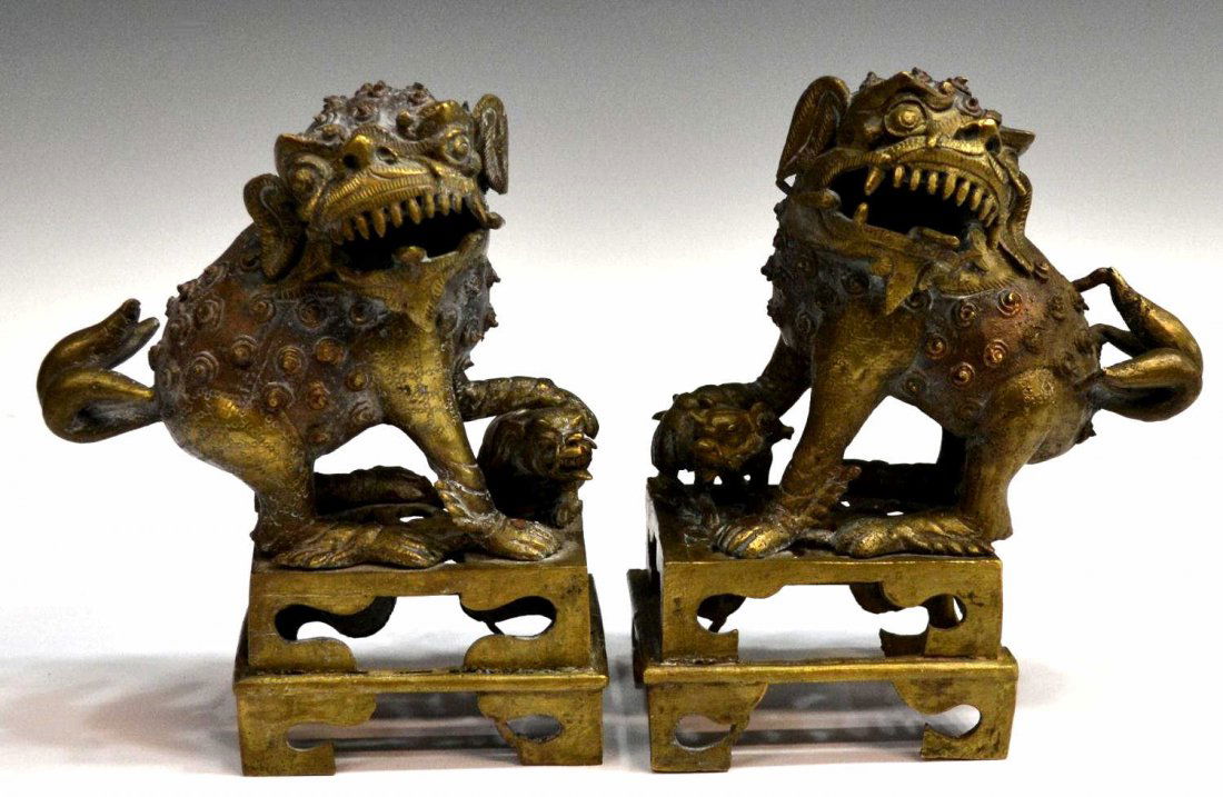 (PAIR) CHINESE GILT BRONZE FOO LION CENSERS: (pair) Chinese patinated bronze figural censers, each in the form of a foo lion with one foot resting on a cub and rising on a pierced bracket base, approx 9.5"h, 8"l, 4.25"w, 12.5lbs total Start Pric