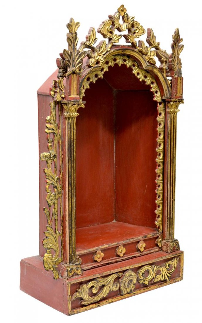 ANTIQUE RELIGIOUS FRENCH COLONIAL ALTAR NICHE: Antique French Colonial parcel gilt altar niche in red paint, 19th c., the architectural case in the Gothic style, carved with fleur-de-lis line the arch flanked by two columns enclosed by carved foli