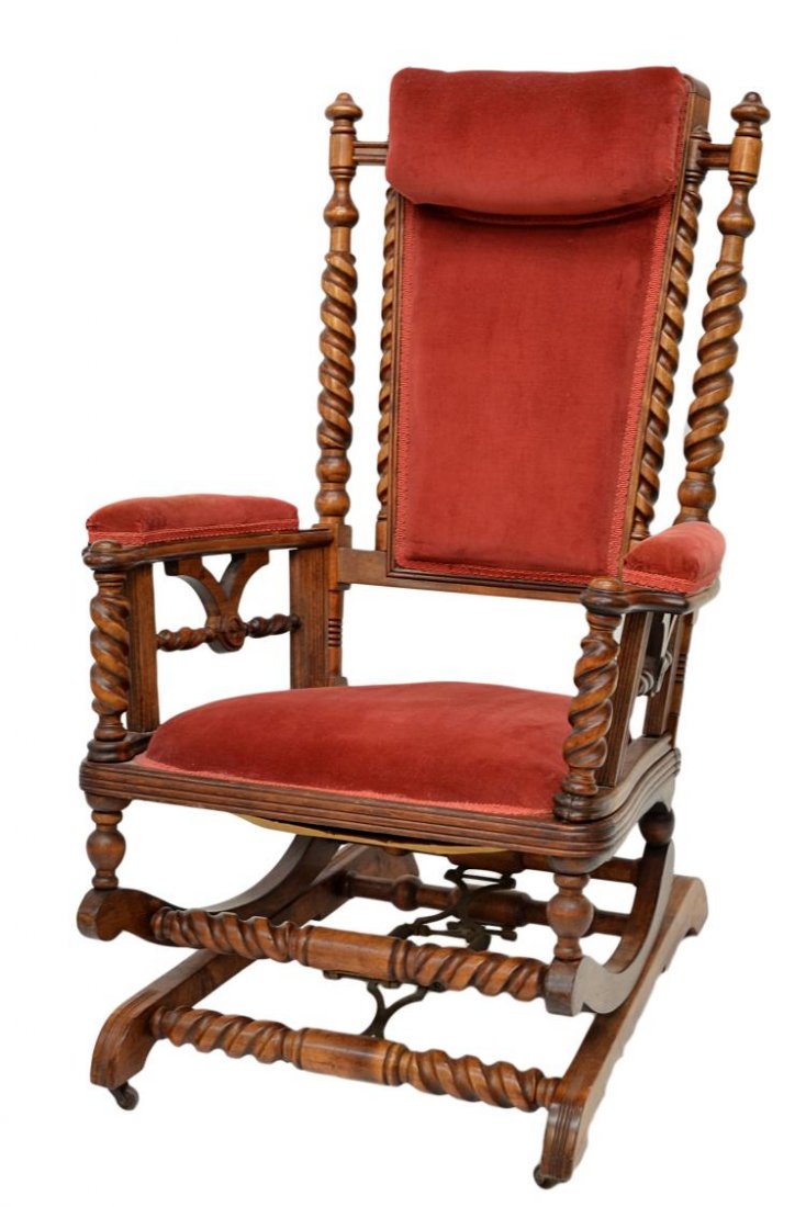 AMERICAN VICTORIAN PLATFORM ROCKER: American Victorian walnut framed platform rocking chair, c. 1900, twist columns, arm supports stretchers, finished in red velvet upholstery with integral head rest, 40.5"h, 27"w, 28"d Start Price: $10
