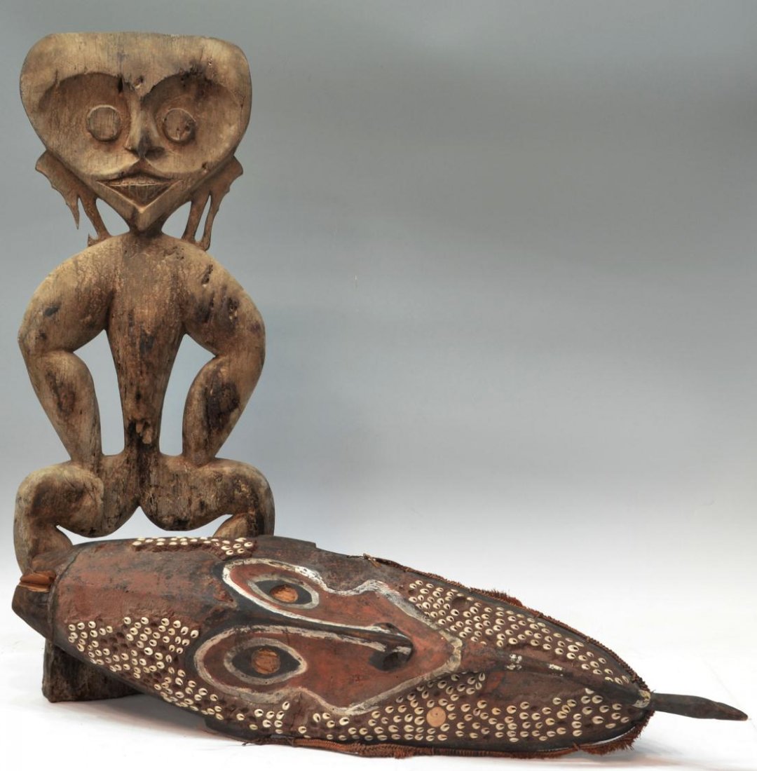 (2)NEW GUINEA CARVED TRIBAL MASK & S PACIFIC TOTEM: (lot of 2) Carved wood tribal items, comprising: (1) gable mask, Papua New Guinea, wide eyes and stretched lip forming into a birds head at chin, traditional painted wood having mud and cowry shell ov