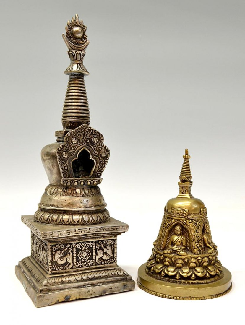 (2) BUDDHIST STUPA SHRINES, NEPAL / TIBET: (lot of 2) Buddhist metal stupas, Nepal / Tibet, early 20th c.: (1) silver gilt metal with a symbolic reliquary top, a seated Buddha on the interior, rises over the shrine, three lines of prayer in ra