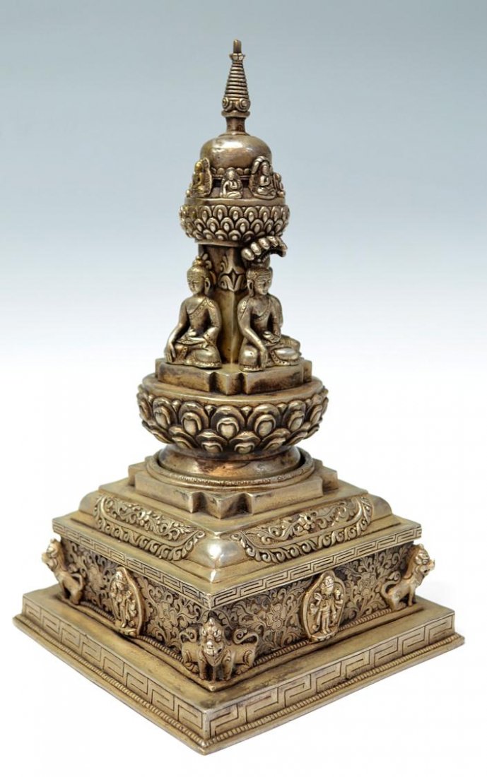 BUDDHIST STUPA SHRINE, NEPAL / TIBET: Buddhist gilt silver metal consecrated stupa, Nepal / Tibet, mid 20th c., the symbolic reliquary top set over four seated Buddhas (removable), is fitted to the circular opening on the base, each corne