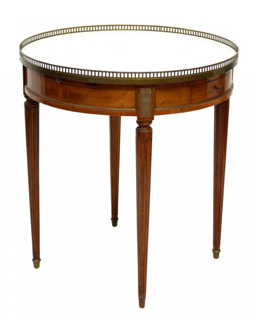 LOUIS XVI STYLE CIRCULAR MARBLE TOP TABLE: Louis XVI style circular table, 1920's, a white marble top with pierced brass grill over two frieze drawers, two leather top pull out trays, all set on tapered fluted legs with brass caps, one without