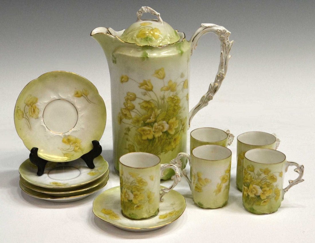 (11) BAVARIAN PORCELAIN CHOCOLATE SET: (lot of 11) Bavarian porcelain chocolate set, decorated in soft green and yellow foliage, flower form handles and gilt trim, comprising: (1) chocolate pot, 9"h; (5) cups, 3"h; together with (5) saucer