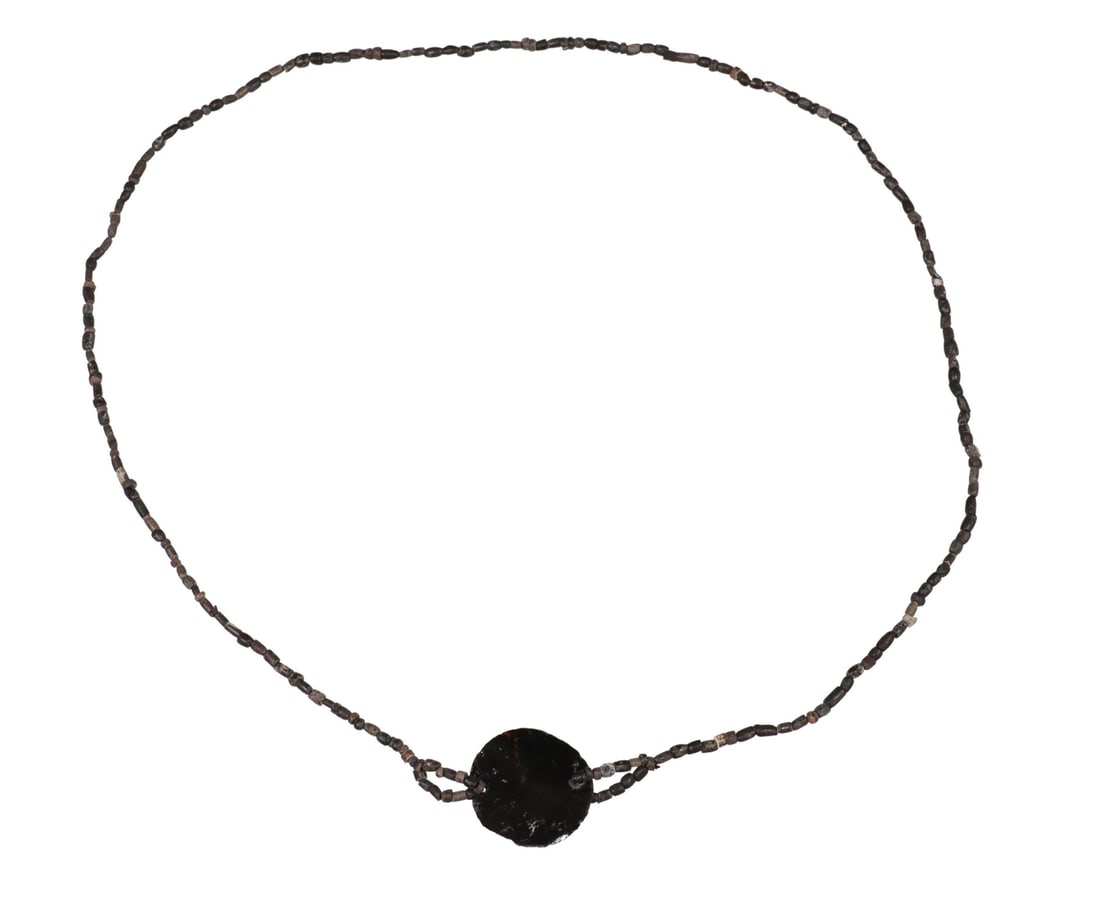 PRE-COLUMBIAN AZTEC OBSIDIAN PENDANT NECKLACE: Pre-Columbian seed-form pendant necklace, Aztec, c.1300-1500AD, central obsidian pendant, on strand composed of small stone beads, pendant: approx 1 1/8"h, 1"w, necklace: approx 24"l, 8.3 grams **Note