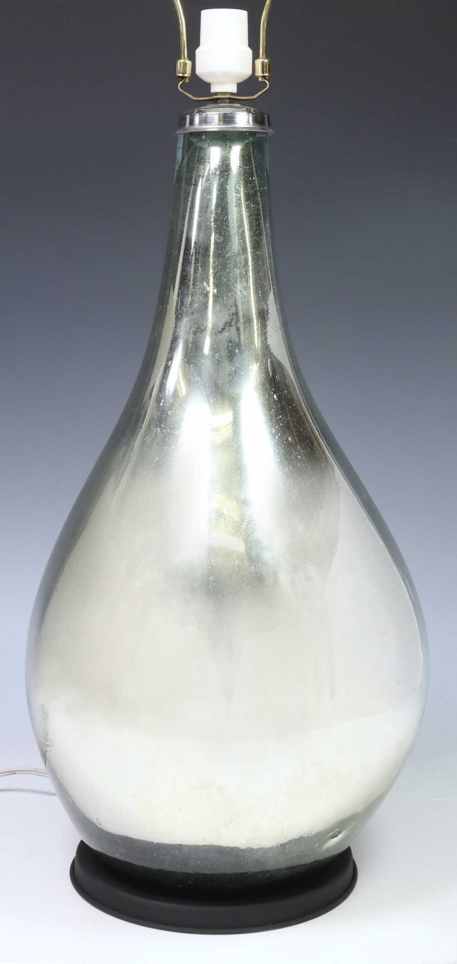 MODERN MERCURY GLASS TABLE LAMP, MEXICO: Modern table lamp, in the manner of Luis Barragan (Mexican, 1902-1988), 20th c., blown glass body in a mirrored metallic silver-tone finish, on black-painted metal base, observed operating, to top of 