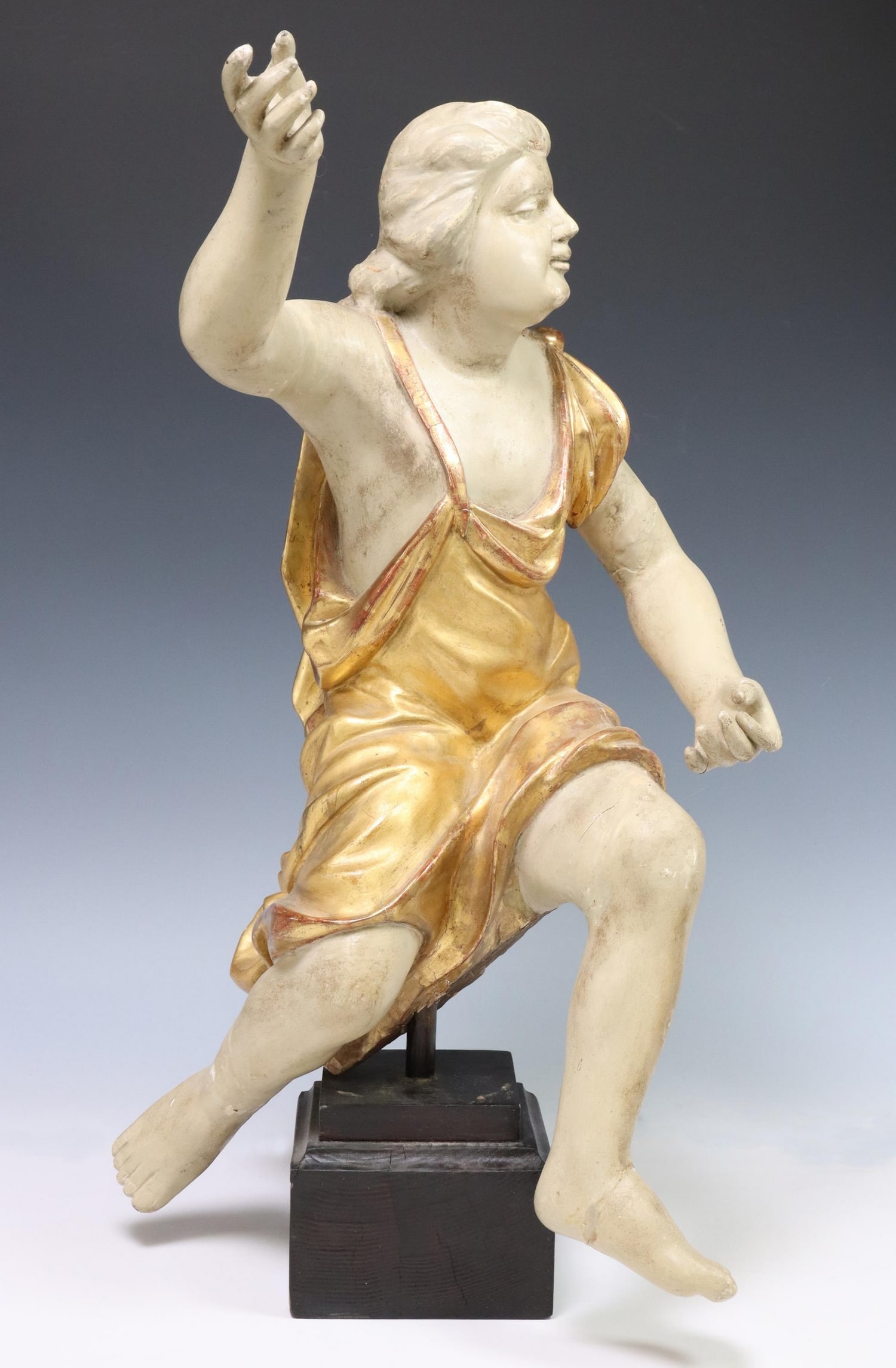 CONTINENTAL PARCEL GILT CARVED WOOD FIGURE 19TH C.: Continental gesso over carved wood figure, 19th c., modeled as a male in dynamic pose, with gilt drapery, rising on squared wood stand, intact with restoration, approx 25.25"h, 13"w, 10"d, 12lbs **Pro