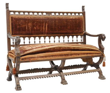 RENAISSANCE REVIVAL CARVED WALNUT UPHOLSTERED SETTEE SOFA: Renaissance Revival carved walnut settee/ sofa, 19th c., padded back and seat in worn velvet upholstery, arcaded back rail, scrolled arms with lion mask terminals, triple curule base joined by cross s