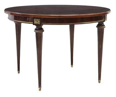 FRENCH LOUIS XVI STYLE FLAME MAHOGANY DINING TABLE: French Louis XVI style flame mahogany extension table, 20th c., having round top, over apron with gilt metal trim, rising on capped fluted legs, no leaves present, lacking metal accent, approx