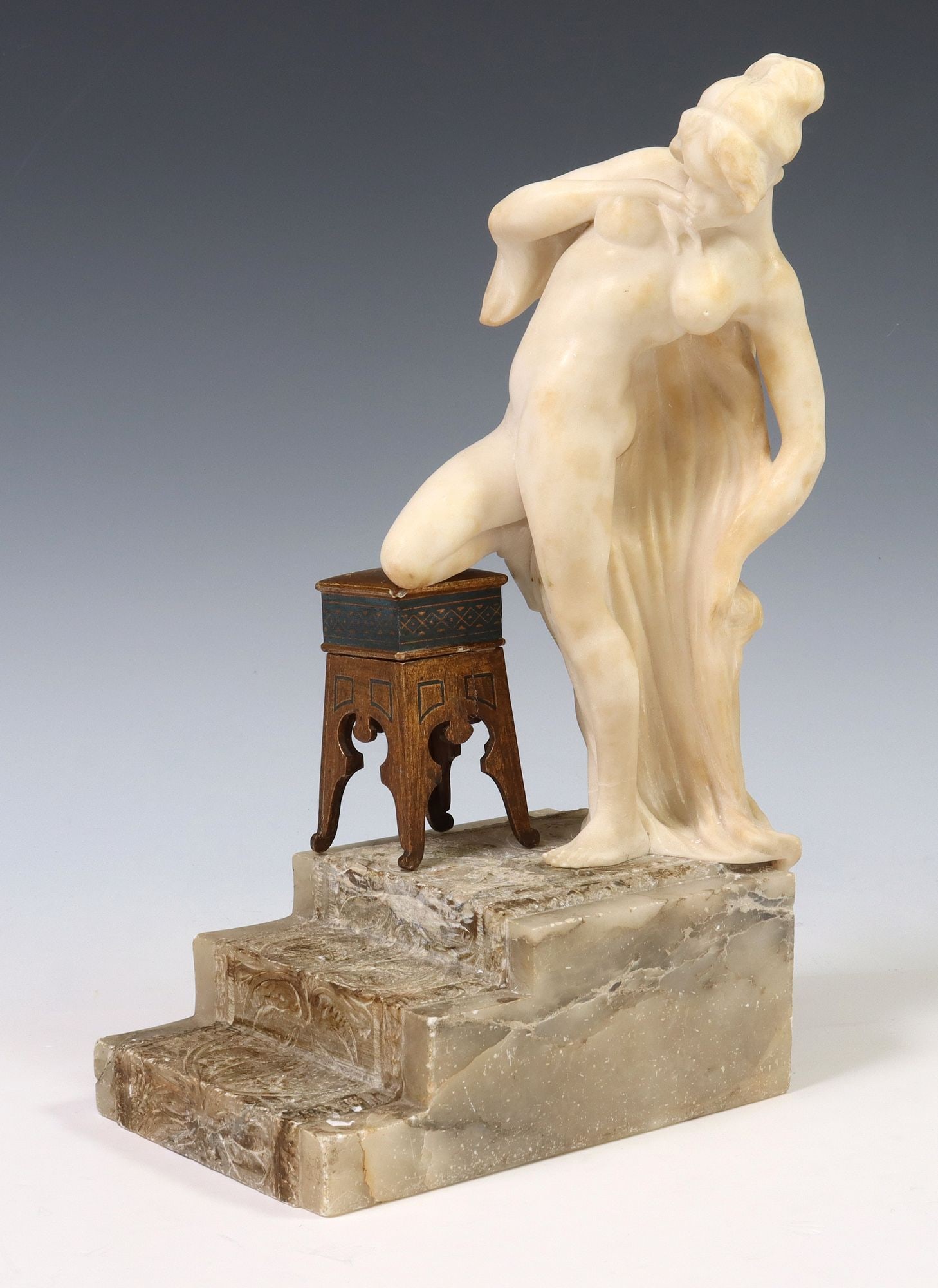PIETRO CECCARELLI (D.1949) CARVED ALABASTER FEMALE NUDE: Carved alabaster sculpture, Female Nude Atop Steps, signed at back Pietro Ceccarelli, Firenze (Italian, 1888-1949), accompanied by gilt painted wood stool, approx 16"h, 9.5"w, 6.25"