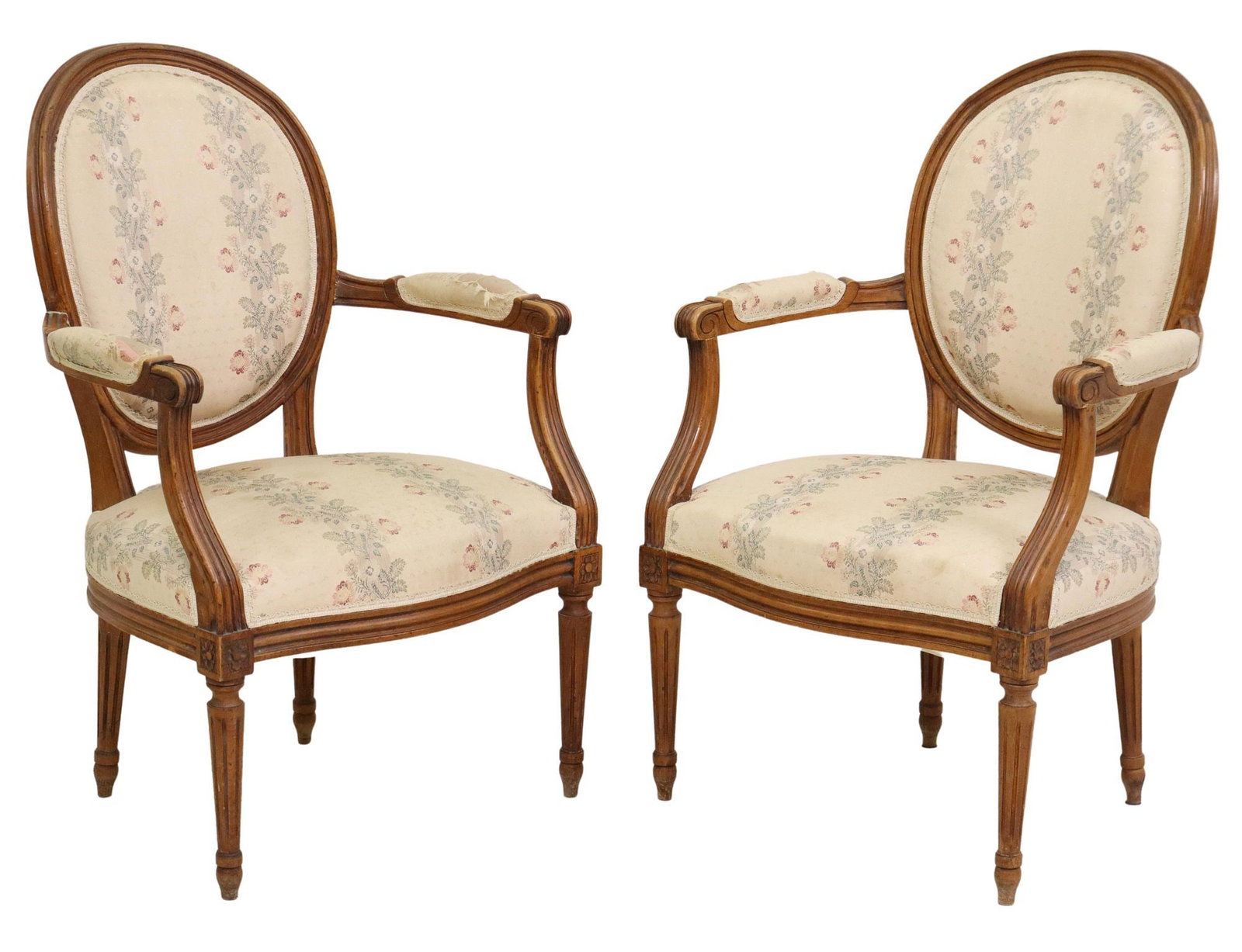 (2) LOUIS XVI STYLE UPHOLSTERED FAUTEUILS: (pair) Louis XVI style armchairs, 20th c., oval medallion back, in floral pattern upholstery, scrolled handholds, rising on fluted and tapered legs, ending on blunt arrow feet, wear to arms, approx 34