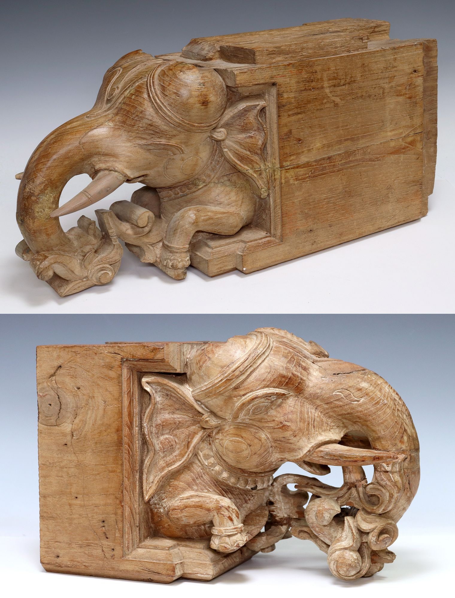 (2) LARGE CARVED WOOD ELEPHANT HEAD ARCHITECTURALS, INDIA: (lot of 2) Carved hardwood architectural elephant heads, India, each having protruding elephant head with trunk issuing scrolled motifs, on squared base, largest: approx 11.25"h, 24"w, 9&quo