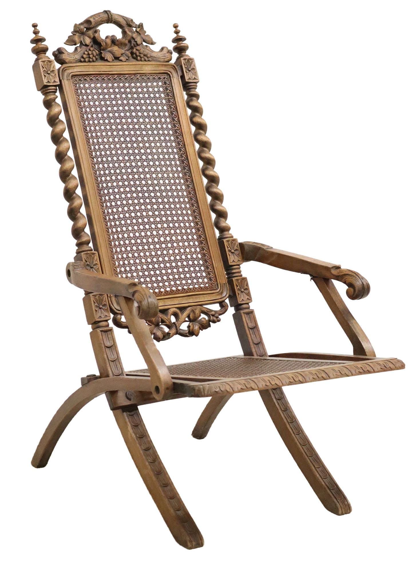 FRENCH HENRI II STYLE CANED FOLDING CHAIR: French Henri II style carved folding chair, early 20th c., having foliate crest with grape vine motifs, flanked by turned finials and spiral twist columns, caned back and seat, rising on cross-f