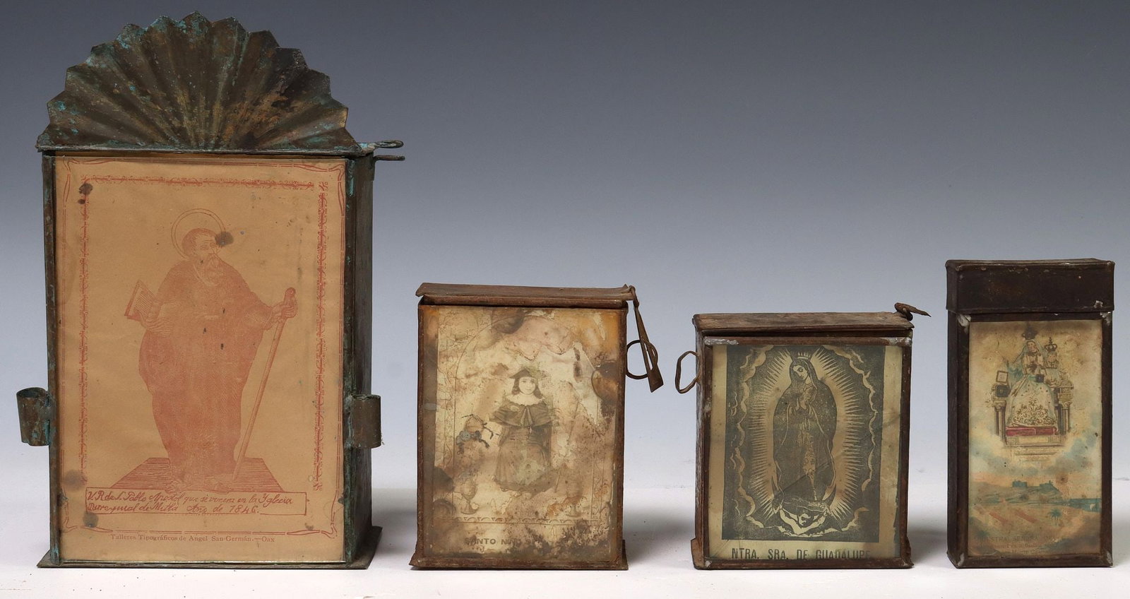 (4) FRAMED TIN ALMS BOXES WITH RELIGIOUS FIGURES: (4) Framed metal alms boxes with religious prints, Mexico, each having slot to top and handles to back, including: (1) La Virgen de Guadalupe, broken glass on frame; (1) Santo Nino de Atocha; (1)