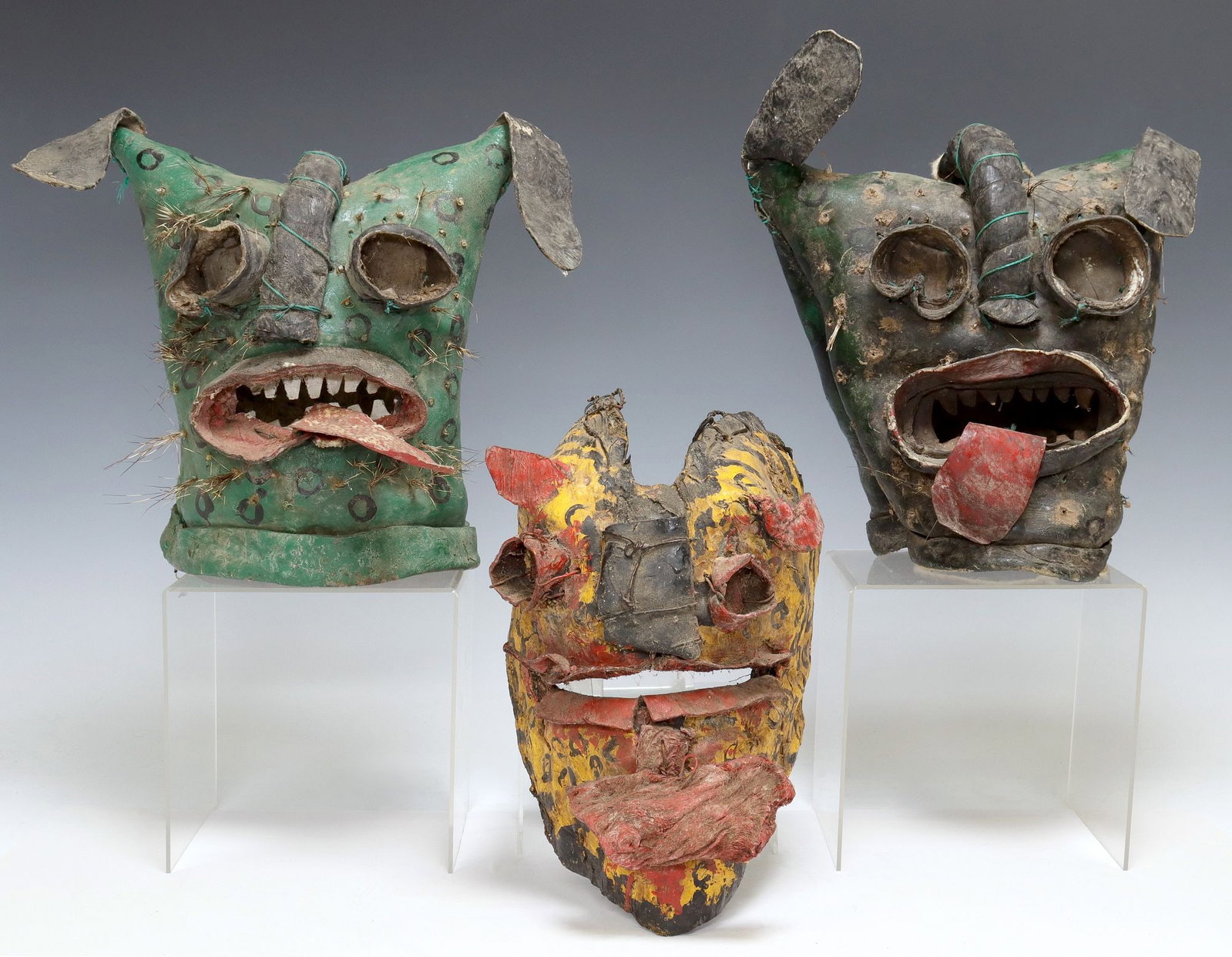 (3) FOLK ART TIGER / JAGUAR DANCE MASKS, GUERRERO, MEXICO: (lot of 3) Folk art tiger/ jaguar dance masks, Guerrero, Mexico, each in polychrome painted hide, with applied features and mouth agape revealing tongue, including: (2) in green, (1) in yell