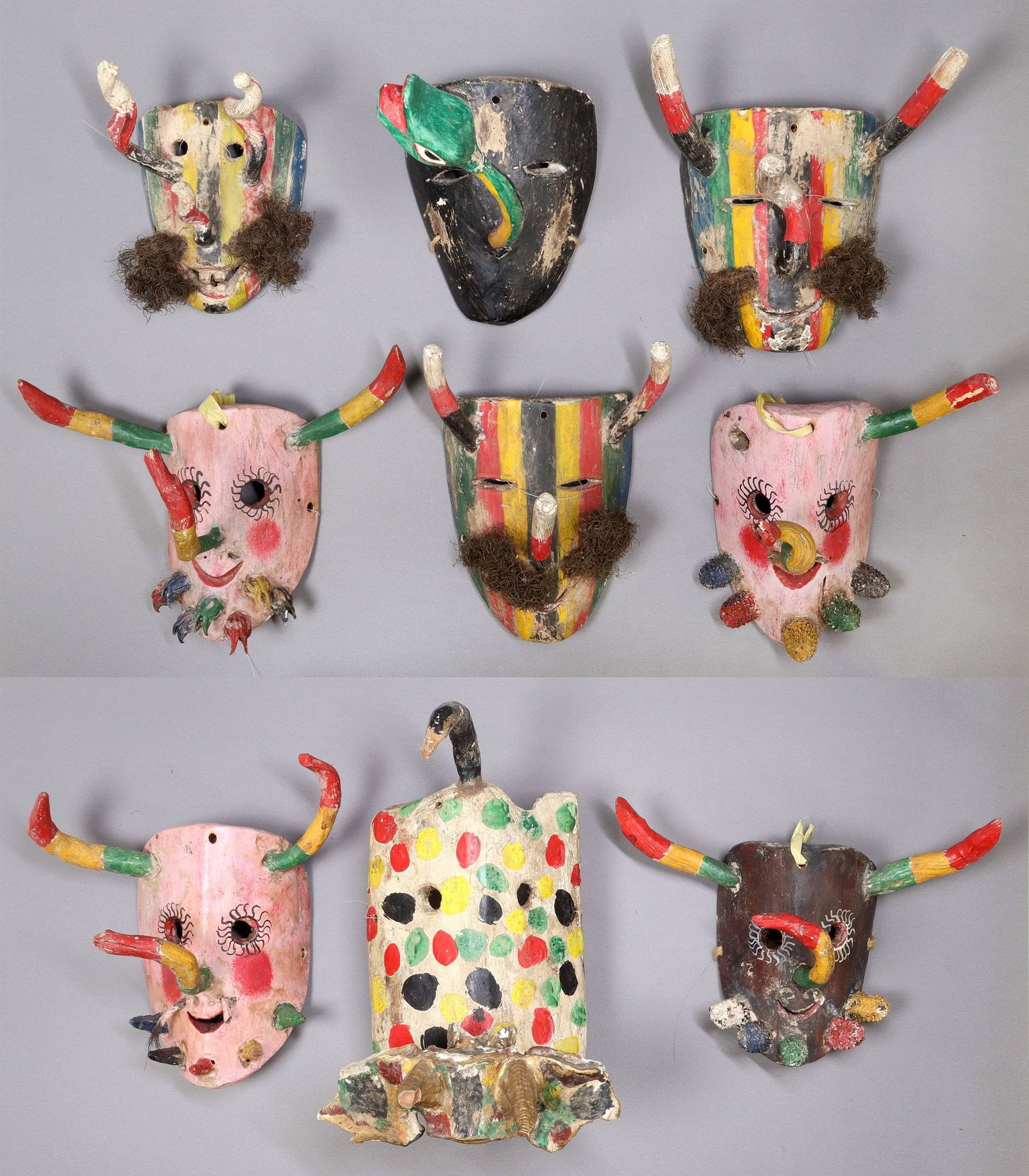 (9) MEXICO FOLK ART CARVED & PAINTED WOOD MASKS: (lot of 9) Mexican folk art polychromed carved wood dance masks, including: (3) striped with organic fibers as moustache; (1) figural mask with animal features; (1) with protruding snake, largest: app