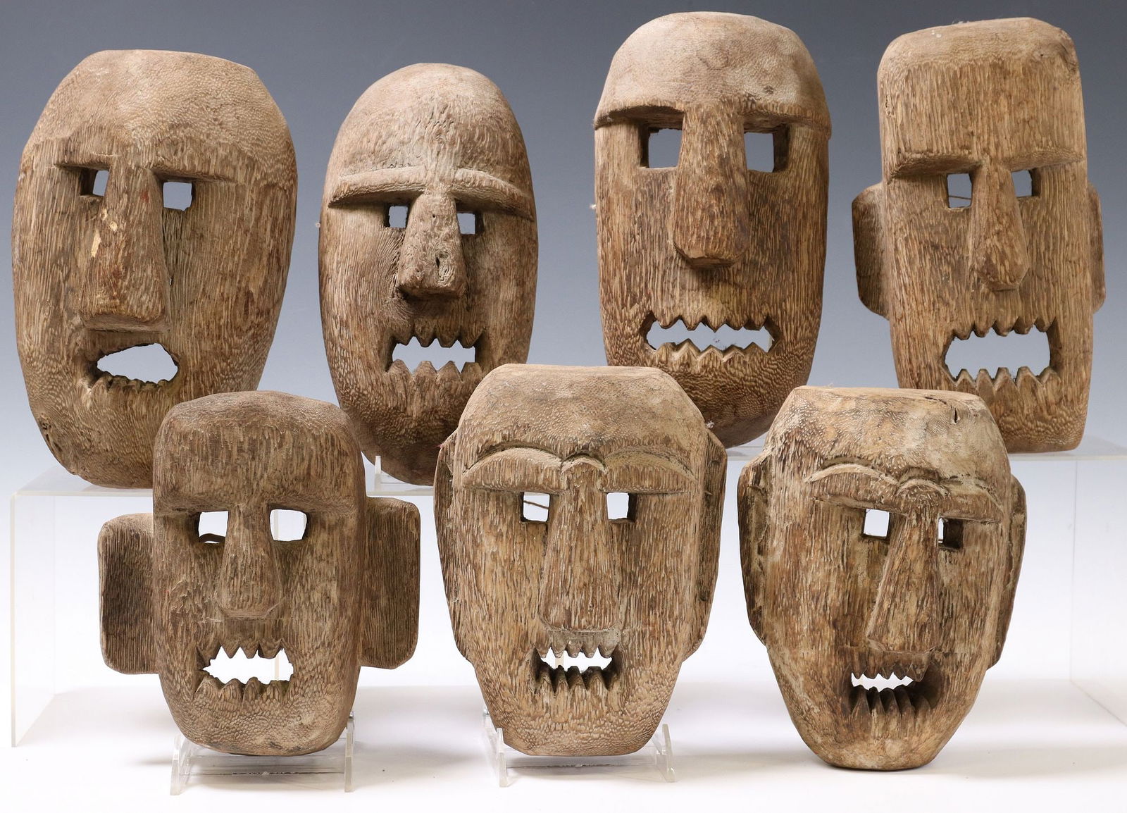 (7) COLLECTION OF CARVED WOOD MASKS: (lot of 7) Collection of carved wood masks, possibly Mexico, having elongated faces with protruding noses, ears and teeth, each with hanging material, approx 10"h, 6.5"w, 3.5"d, 5.