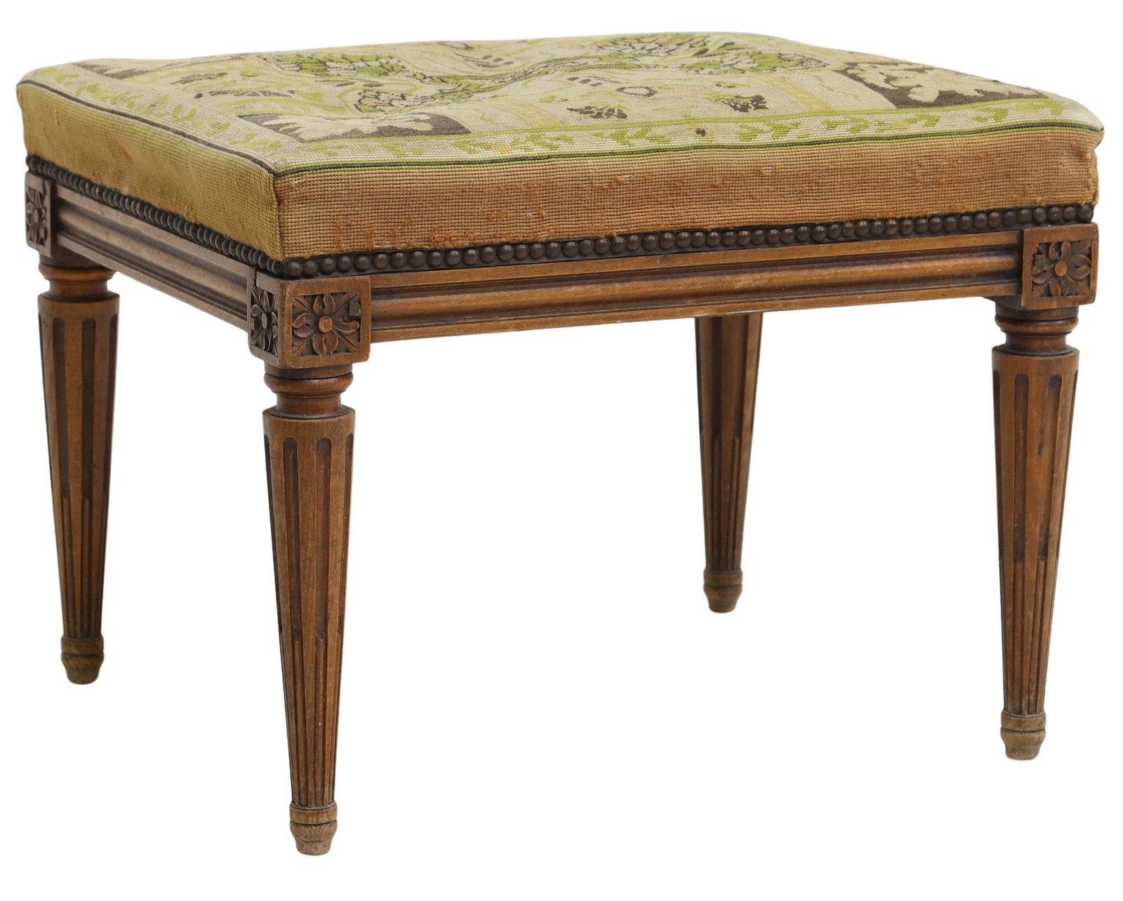 FRENCH LOUIS XVI STYLE NEEDLEPOINT FOOT STOOL: French Louis XVI style foot stool, early 20th c., upholstered seat in needlepoint textile, on tapering fluted legs, approx 17"h, 22.5"w, 19.5"d