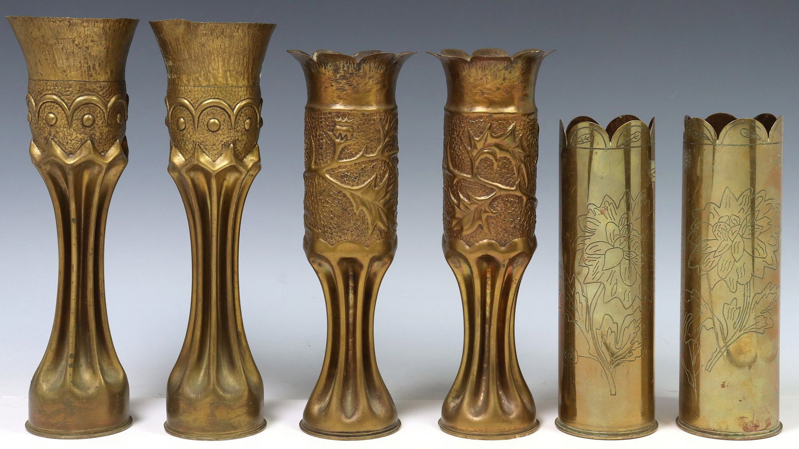(6) FRENCH WWI-ERA TRENCH ART ARTILLERY SHELL VASES: (lot of 6) French WWI-era trench art vases, fashioned from artillery shells, including: (4) rising on waisted stem, (two) having scalloped rim and repousse foliate motifs, (2) having scalloped rim, in