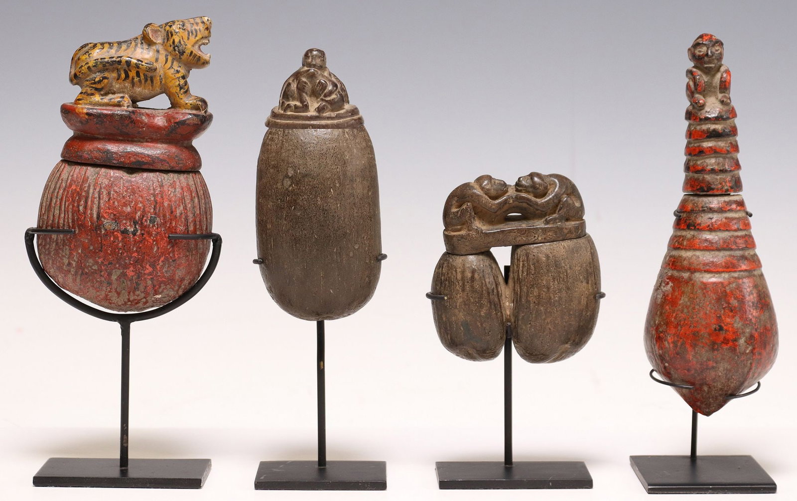 (4) CARVED & PAINTED SEED POD BOXES ON DISPLAY STANDS: (lot of 4) Carved and polychrome painted seed pod boxes, possibly Southeast Asia, varied designs, each having lid modeled as an animal or human figures, accompanied by metal display stand, largest: ap