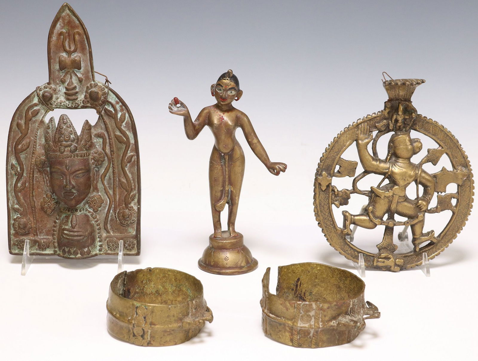 (5) SOUTHEAST ASIAN GILT METAL PLAQUES, CUFFS & FIGURE: (lot of 5) Southeast Asian patinated and gilt metal items, including: (2) brass cuff bracelets, each malleable band with raised birds and spiral-form motifs, largest: 1 5/8"w, interior: approx 9&