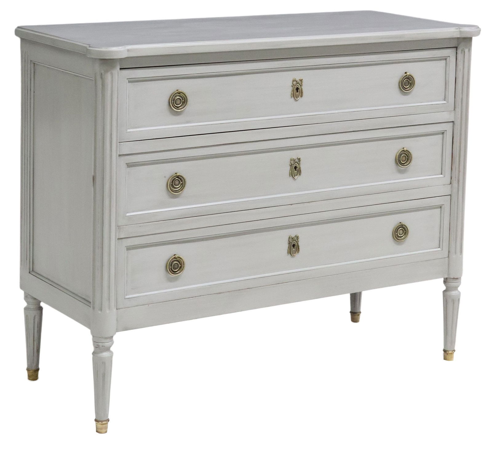 FRENCH LOUIS XVI STYLE PAINTED THREE-DRAWER COMMODE: French Louis XVI style painted commode, 20th c., fitted with three drawers, flanked by fluted corner posts, rising on fluted tapered legs, ending on brass cap feet, approx 32.5"h, 40.5"w, 17