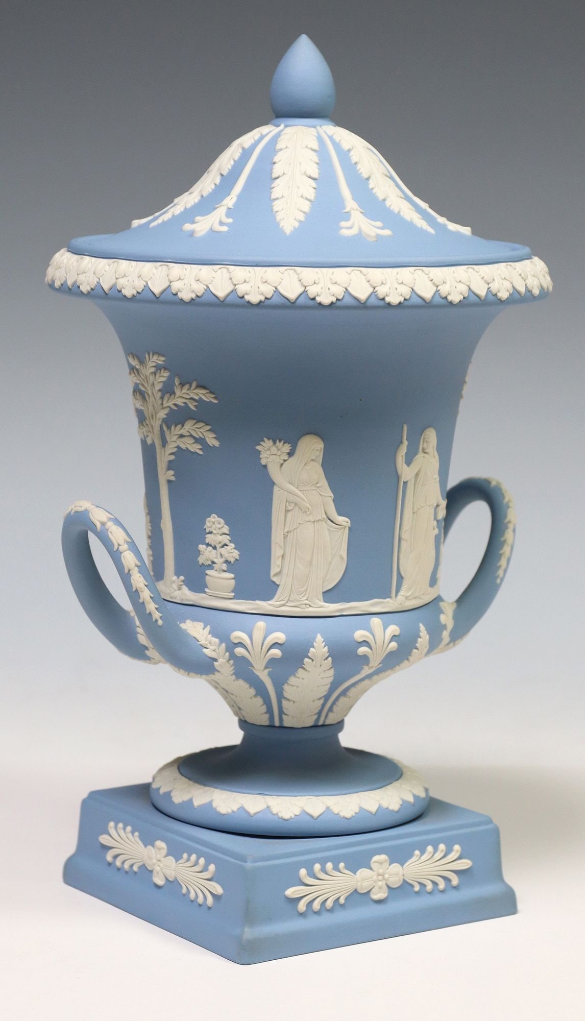 ENGLISH WEDGWOOD BLUE JASPERWARE CAMPAGNA-FORM URN & COVER: English Jasperware dual-handled campagna-form urn and cover, Wedgwood, 20th c., domed cover with radial acanthus leaves, body with procession of classical figures in relief from "An Offering to Peace,