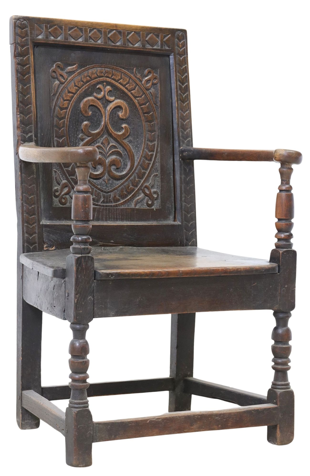 ENGLISH CARVED OAK WAINSCOT CHAIR: English carved oak wainscot chair, early 19th c., having rectangular back with carved geometric trim encasing recessed panel with central ovoid form and scrolls, with scrolled arms over trap
