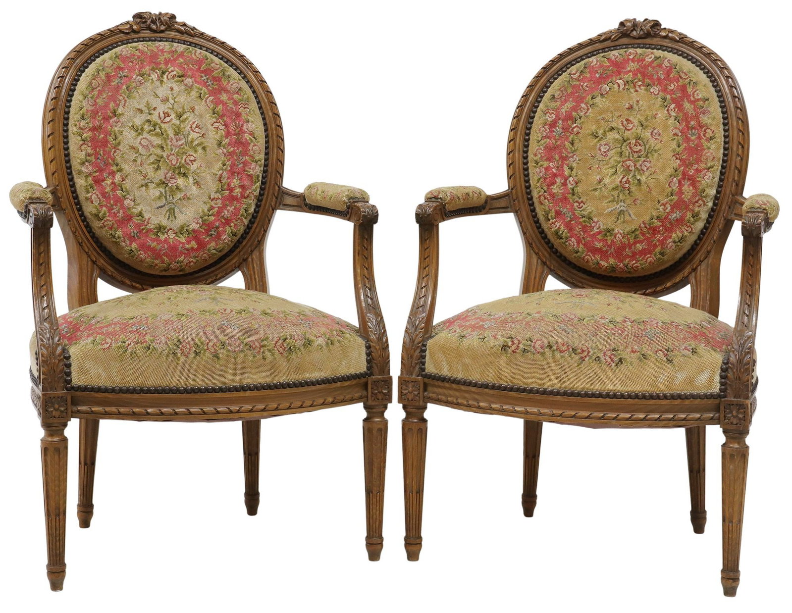 (2) FRENCH LOUIS XVI STYLE NEEDLEWORK UPHOLSTERED FAUTEUILS: (pair) French Louis XVI style armchairs, early 20th c., floral crest over frame with ribbon twist molding, needlework upholstery, on tapering fluted legs, (one) with staining to seat, approx 37.7