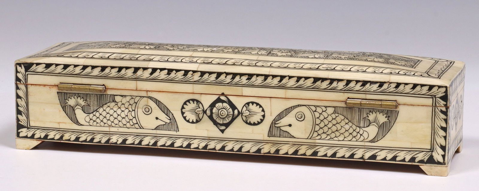DECORATIVE INCISED TILED BONE TABLE BOX, INDIA: Decorative tiled bone table box, India. retailed at Tonzai Home, with incised foliate scrolled designs and figural fish, having hinged top with divided interior, retaining tag underfoot, approx 2