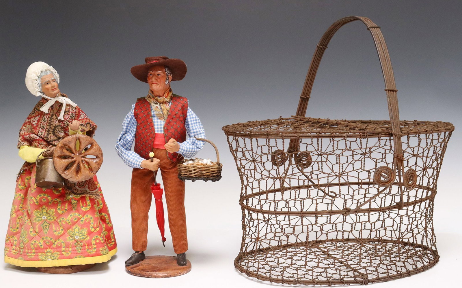 (3) FRENCH SANTON DE PROVENCE CERAMIC DOLLS & WIRE EGG BASKET: (lot of 3) Rustic wire basket and folk art figures, early 20th c., including: (1) patinated metal wire egg basket, hinged lids currently wired closed, approx 14"h, 15"w, 9.5"d; (2)