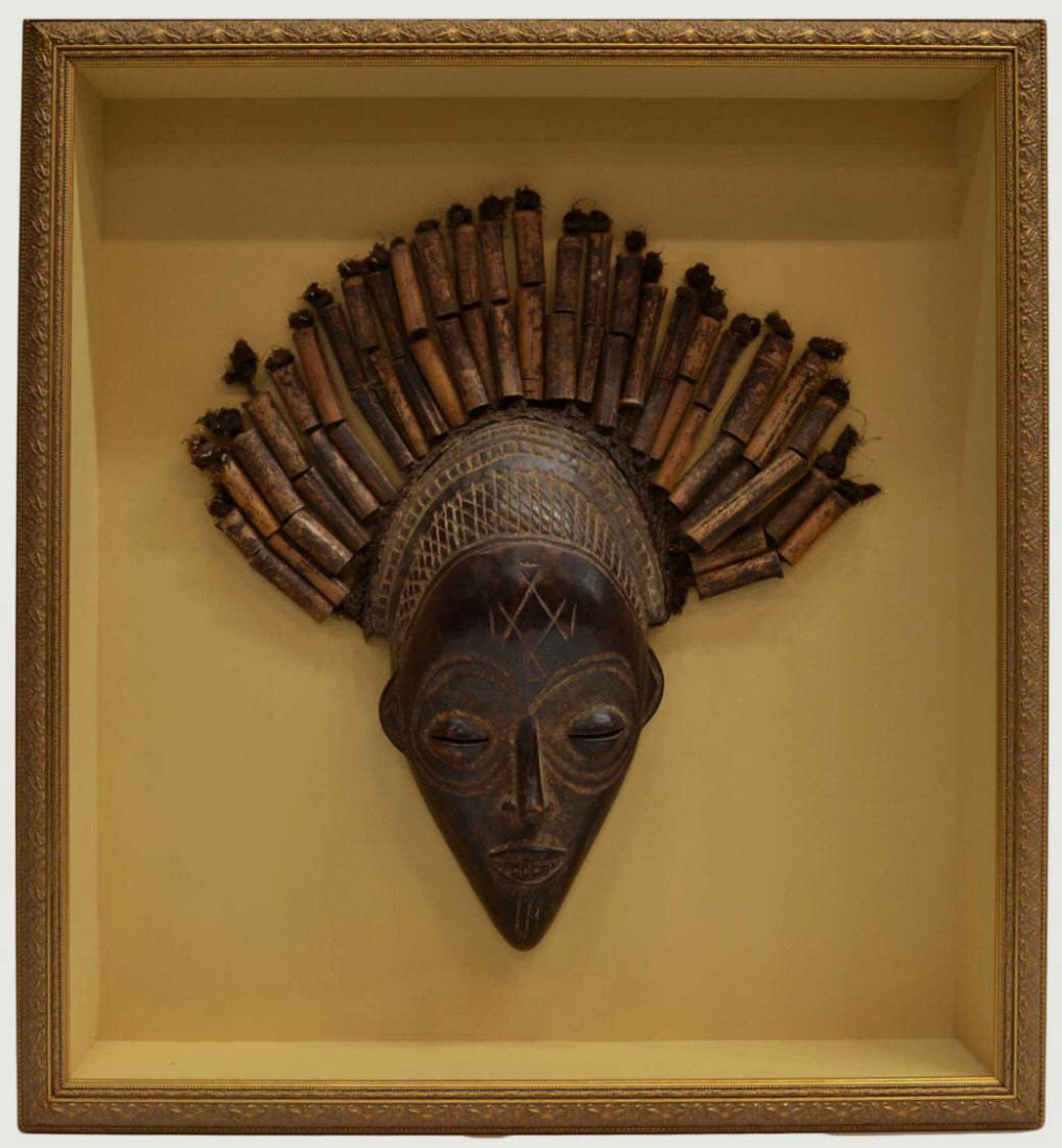 FRAMED AFRICAN WOOD TRIBAL MASK: Shadow box framed African carved wood mask, face carved with geometric tribal patterns, splayed beaded rope hair, mask: approx. 19"h, 17"w (inclusive of hair), overall: 26.25"h, 24.25"w, 10.5lbs Start