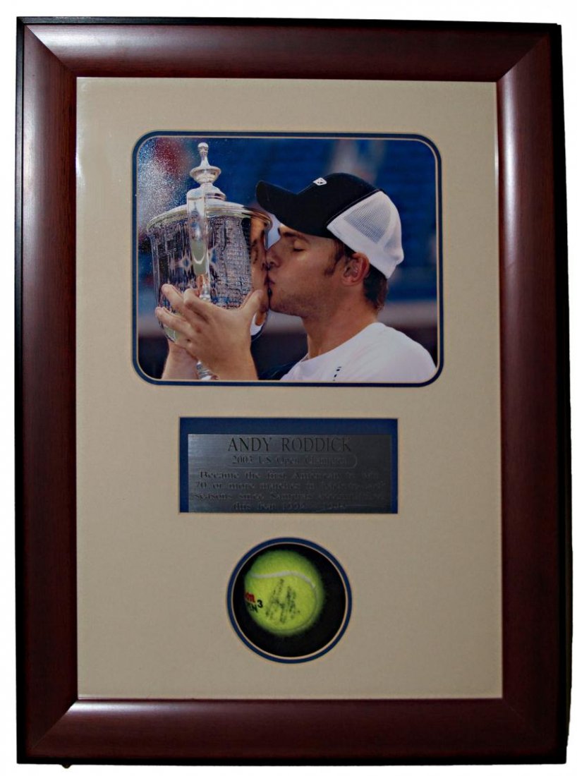ANDY RODDICK SHADOW BOX SIGNED TENNIS BALL: An Andy Roddick signed tennis ball, enclosed in a shadow box frame with photo and plaque 'Andy Roddick, 2003 US Open Champion, the first American to win 70 matches in back-to-back seasons since Sampra