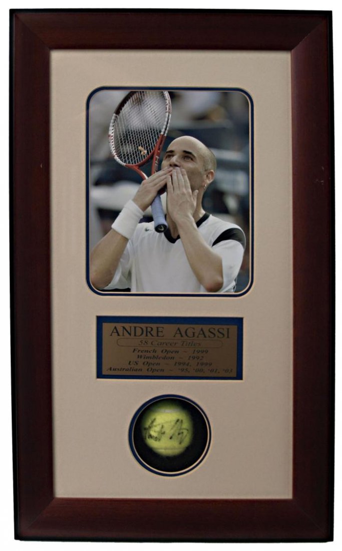ANDRE AGASSI SHADOW BOX SIGNED TENNIS BALL: Andre Agassi signed tennis ball, enclosed in a shadow box frame with photo and plaque 'Andre Agassi, 58 Career Titles, French Open-1999, Wimbledon-1998, US Open-1994, 1999, Australian Open- '95, '00, 