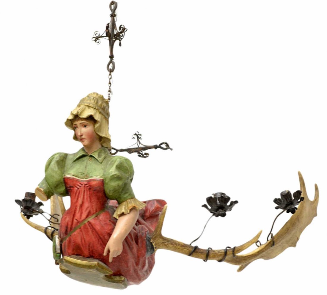 19TH C. BAVARIAN FIGURAL ANTLER CHANDELIER: A Black Forest figural candelier having four lights, 19th c., a pair of large stag antlers support the carved polychrome figure of a maiden, lacking one arm, approx 16"h, 26"l, 13lbs Start Price: $80.