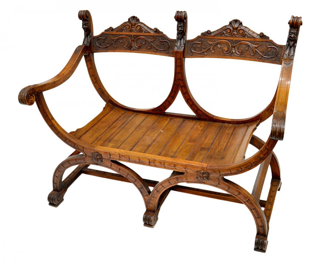 ITALIAN RENAISSANCE REVIVAL SETTEE: Italian Renaissance Revival walnut two seat settee, late 19th c., X form having carved uprights, foliate and mask carved back rail, scrolled arm rests, stylized claw feet, 33.5"h, 43"w, 20.5"d Start P