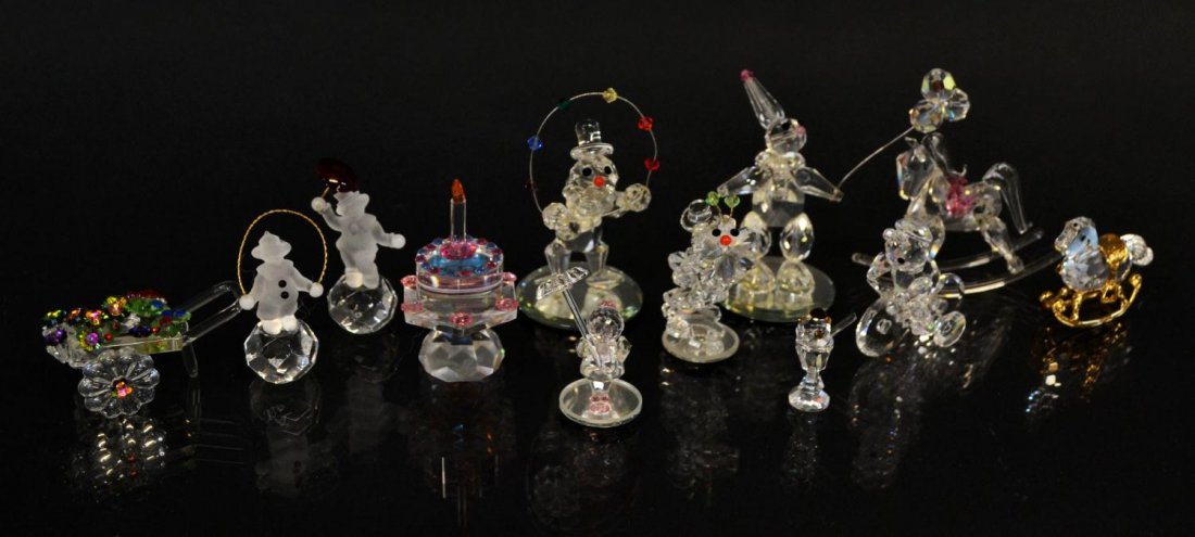 (12) CRYSTAL FIGURES, CLOWNS, ROCKING HORSES, ETC.: (lot of 12) Collection of crystal figures, including, clowns, cake, rocking horses, children, etc. some possibly Swarovski, largest: 2.75"h, 75lbs total Start Price: $50.00
