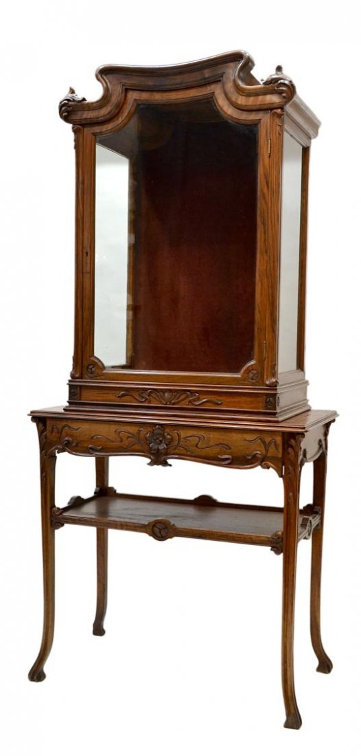 SPANISH ART NOUVEAU WALNUT CAPILLA ON STAND: Art Nouveau walnut capilla on stand, Northern Spain, c. 1900, a scrolled cornice over the original glazing display cabinet with central door, the stand with rectangular top over single drawer and lowe