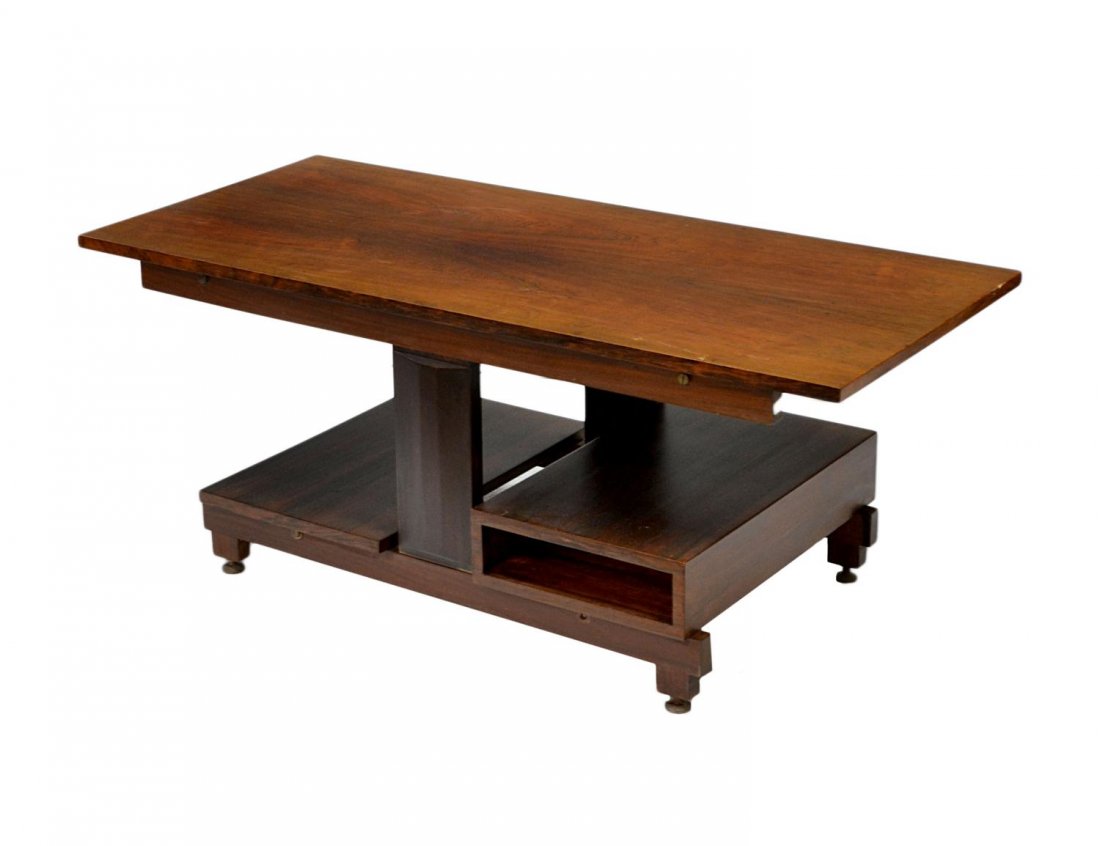 ITALIAN MID-CENTURY MODERN SOFA TABLE: Italian rosewood low sofa table, c. 1960, a rectangular top with central supports over two stepped shelves, set on circular metal adjustable feet, 16"h, 39.5"w, 17.75"d Start Price: $150.00
