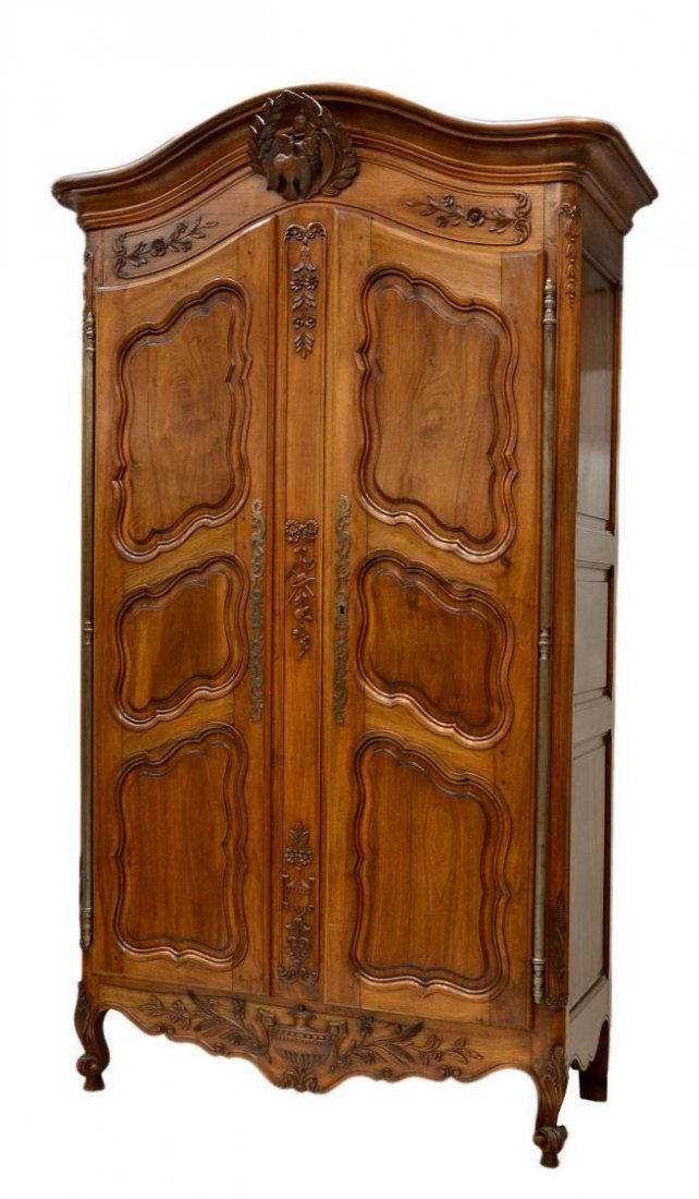 FINE FRENCH PROVINCIAL CARVED WALNUT ARMOIRE: Very Fine French Provincial armoire, 19th c., the shaped cornice above a well carved crest featuring a pair of love birds within a laurel wreath, the case caved in low relief overall with bell flower 