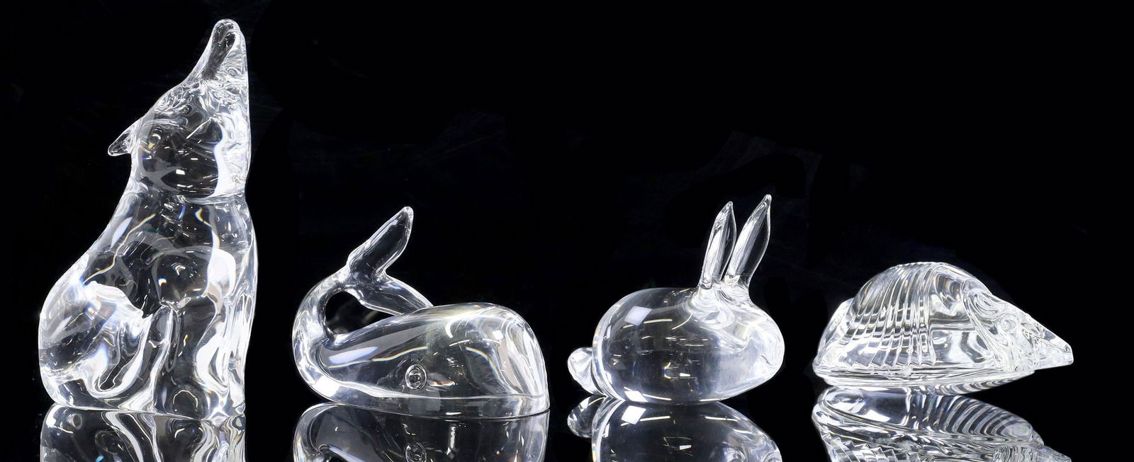 (4) STEUBEN COLORLESS ART GLASS ANIMAL FIGURES: (lot of 4) Steuben colorless art glass figures, including: (1) howling wolf figurine (1) stylized armadillo paperweight, designed by David Dowler (American, b. 1945), minor internal flaw to 