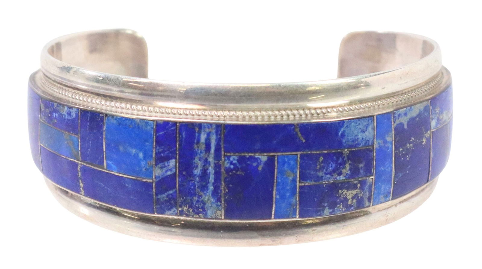 RICKELL & GLENDORA BOOQA ZUNI LAPIS-INLAID STERLING CUFF: Native American sterling silver cuff bracelet, Rickell and Glendora Booqa, Zuni, central register of mosaic inlaid lapis with thin gadrooned trim, approx 1 1/8"w, interior: 5.25"l, gap: