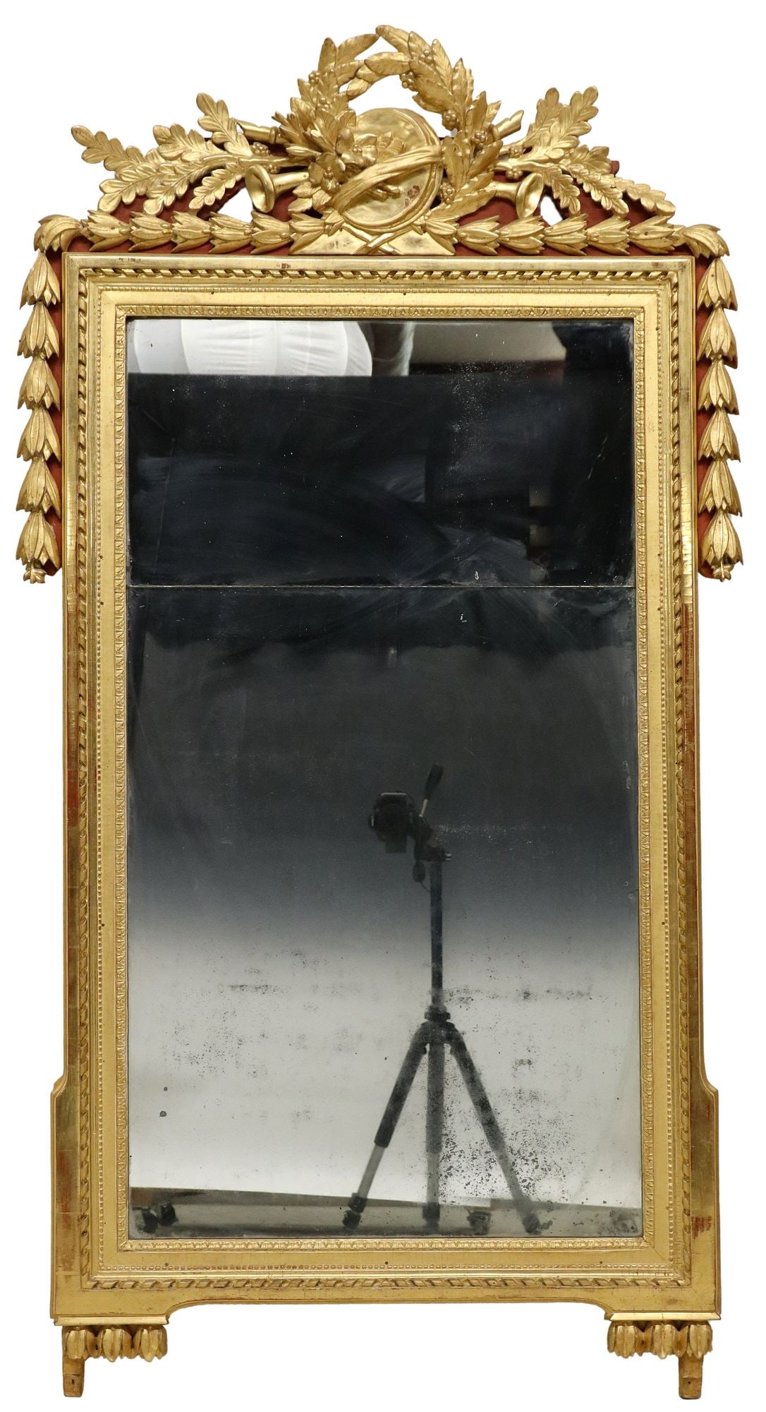 FRENCH LOUIS XVI STYLE GILTWOOD MIRROR, 70" X 37.5": French Louis XVI style giltwood mirror, 19th c., laurel wreath crest with musical instruments, frame with ribbon twist and beaded molding, segmented mirror plate, losses to mirror silvering, approx 69